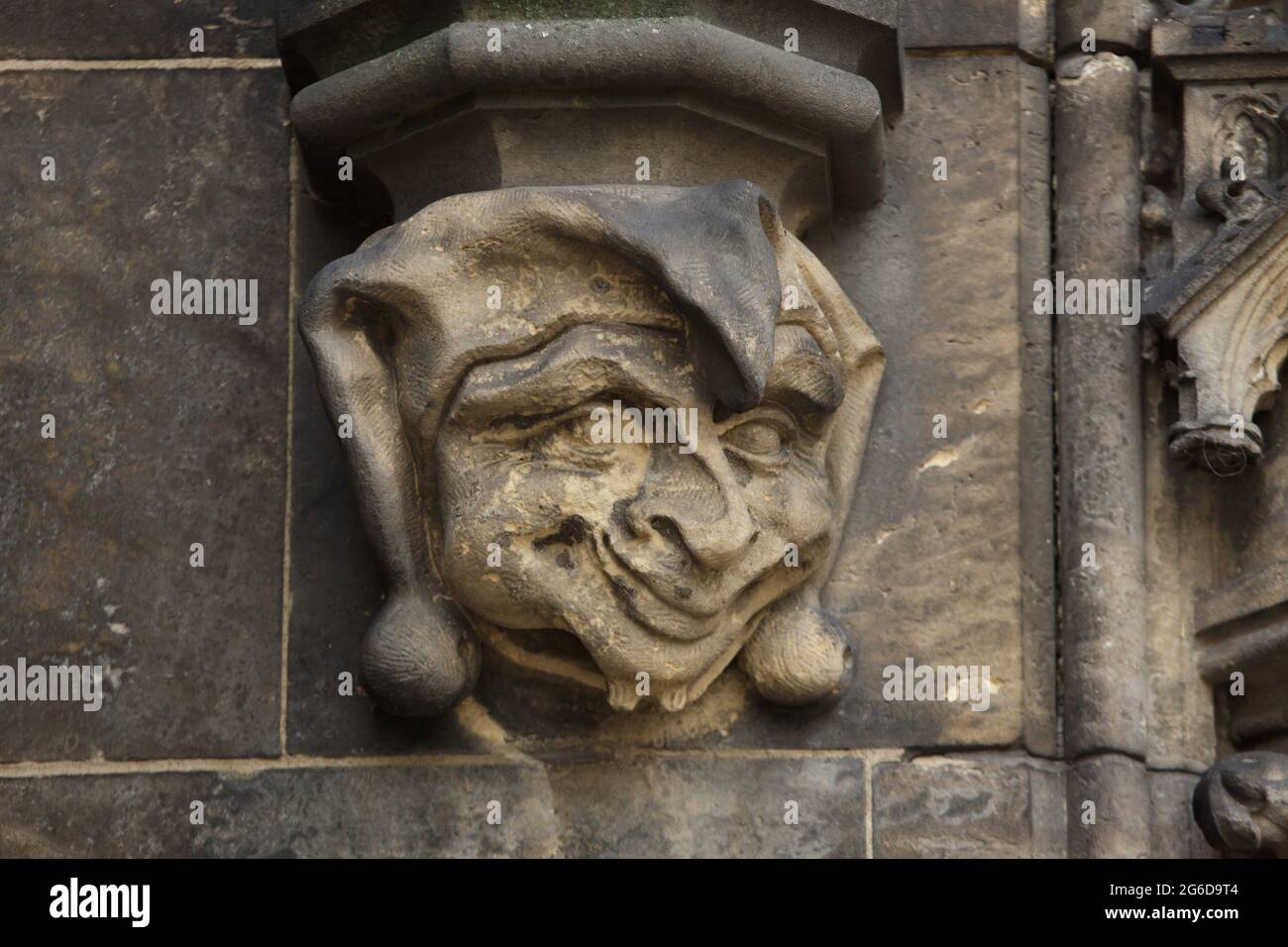 Jester depicted in the corbel of the archivolt of the north portal of the Basilica of Saint Peter and Saint Paul (Bazilika svatého Petra a Pavla) in Vyšehrad in Prague, Czech Republic. The portal designed by Czech architect František Mikš and Czech sculptor Štěpán Zálešák was created between 1901 and 1902. Stock Photo