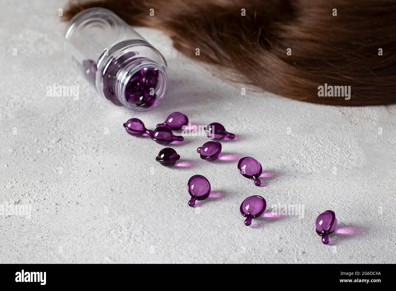 Hair Vitamin Capsules on a Gray Background: Hair Treatment and Care Products With Oil for Damaged, Highlighted, Permed and Colored Hair Stock Photo