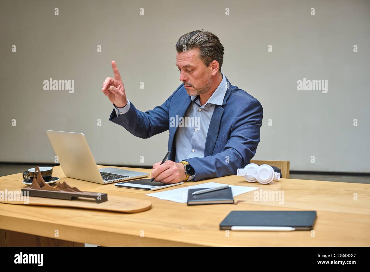 Designer at his desk working on his computer using his tablet Stock Photo