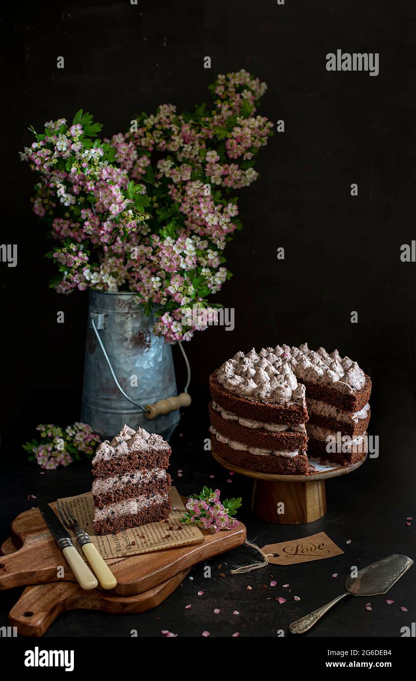 Food photography of chocolate cake, flowers, black background, rustic, vintage Stock Photo