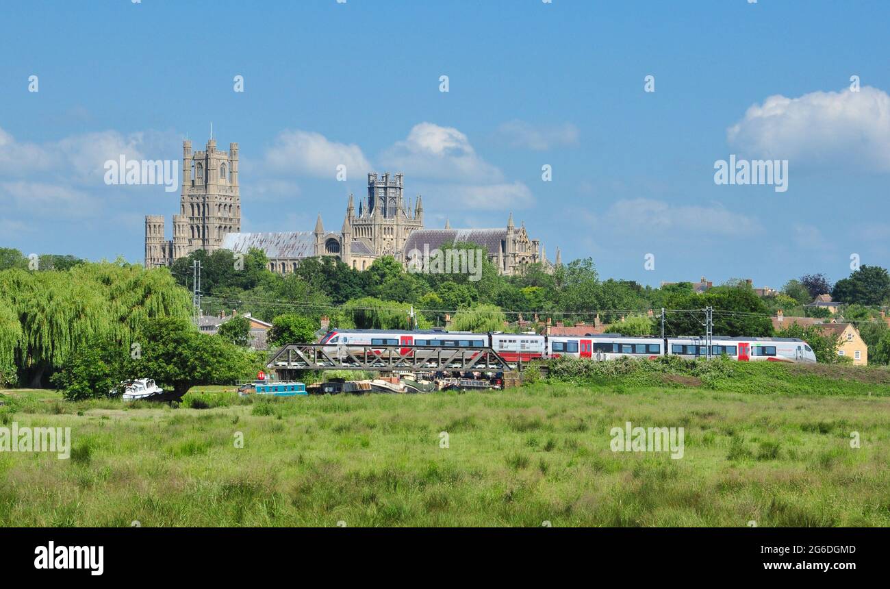 Class 755 passenger train crosses the River Great Ouse with the cathedral as a backdrop, Ely Cambridgeshire, England, UK Stock Photo