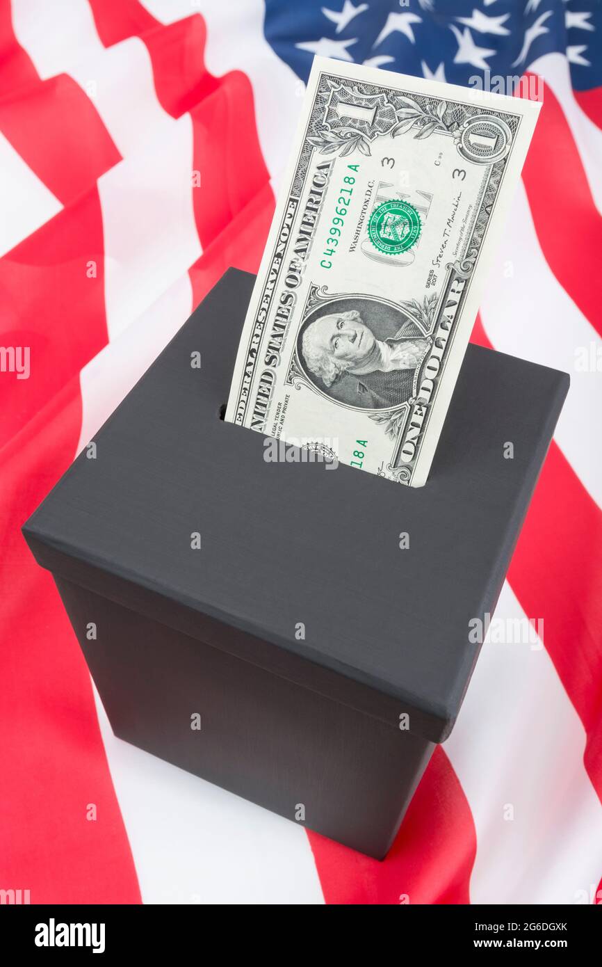 US 1 Dollar / $1 bill with George Washington on obverse side + mock ballot box and Stars & Stripes. For buying votes, US political fundraising. Stock Photo
