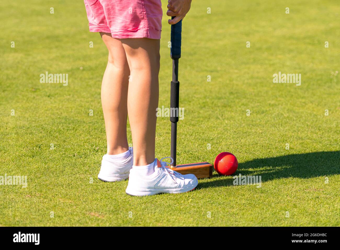 female croquet player hitting the ball with mallet Stock Photo Alamy