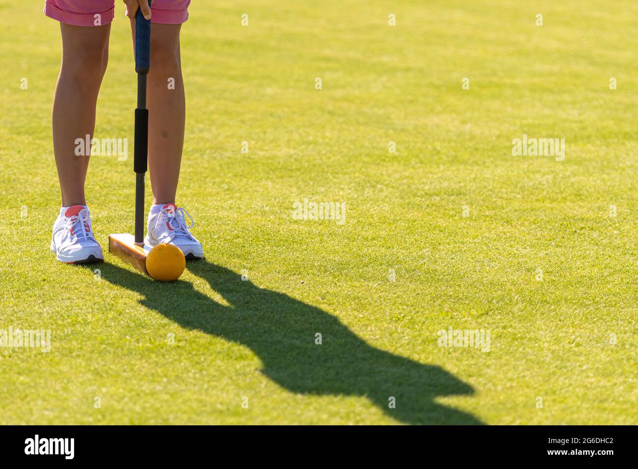female croquet player hitting the ball with mallet Stock Photo Alamy