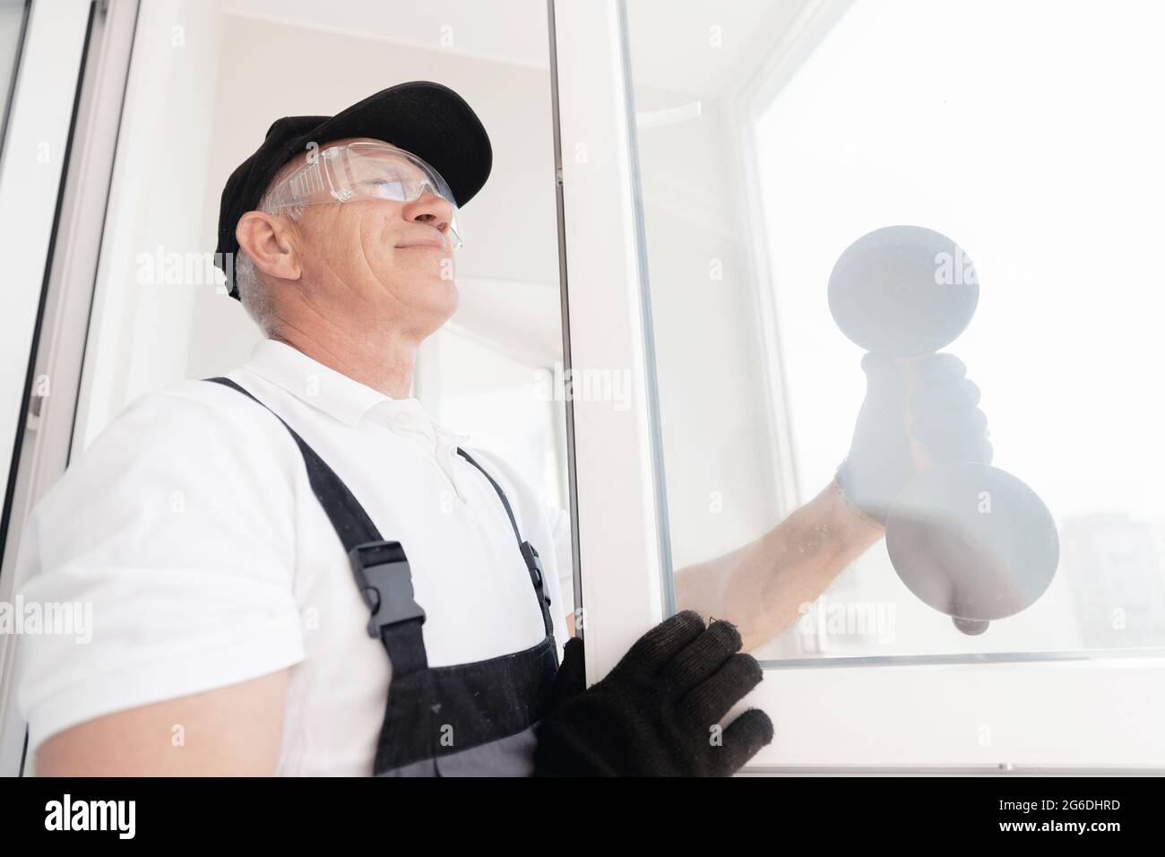 Joinery worker man installs plastic upvc white windows with vacuum ...