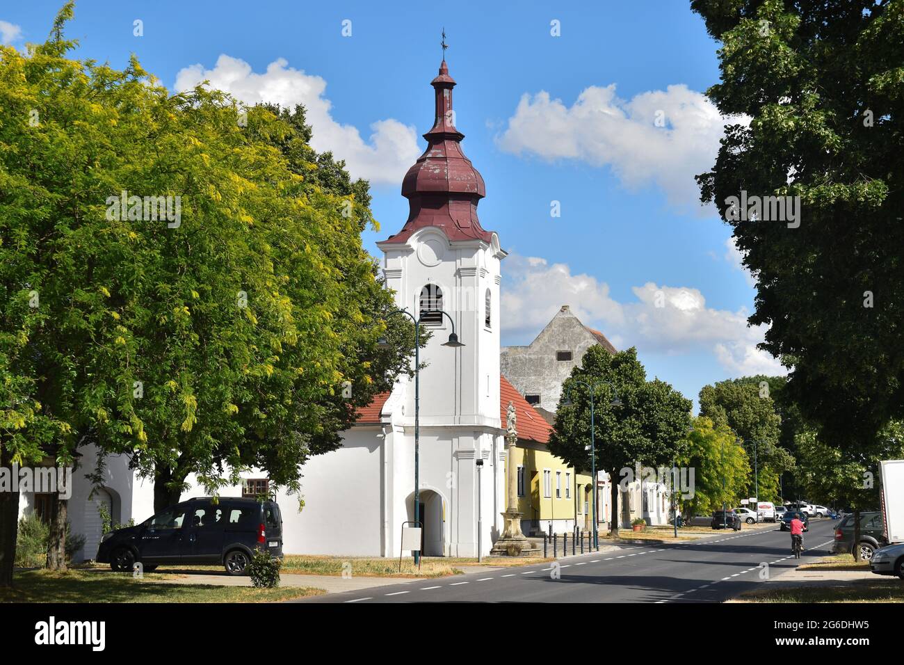 Das Dorf Zurndorf, Burgenland, Österreich. Dorfstraße und katholische Kirche Stock Photo