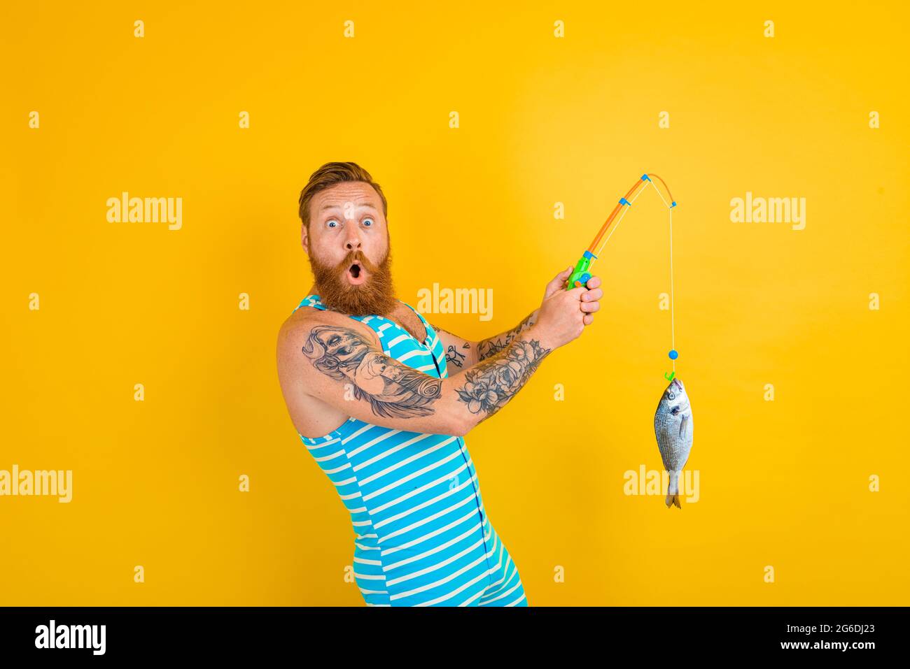 man with beard and swimsuit caught a fish Stock Photo