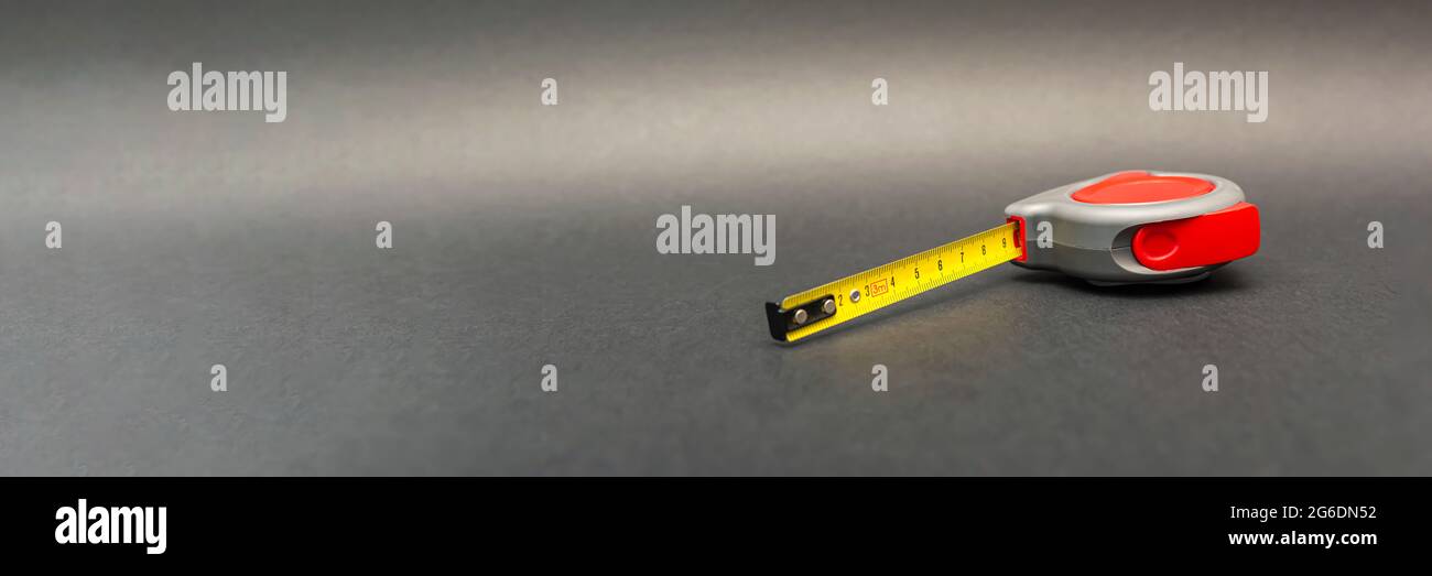 Yellow carpentry tape with metric scale, measuring instrument in millimeters. Copy space Stock Photo