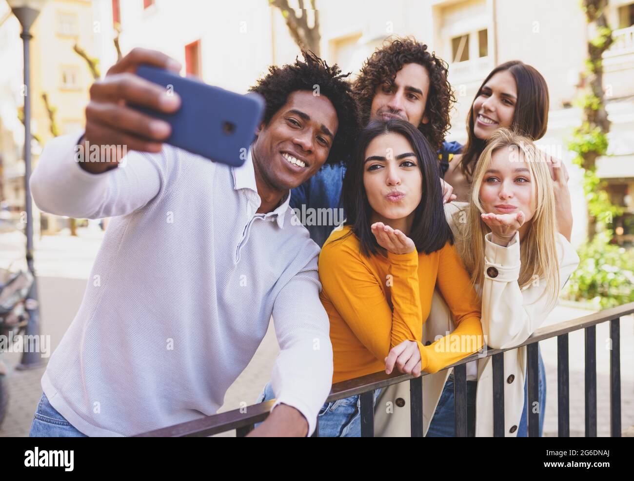 Multiethnic group of friends taking a selfie in the street with a