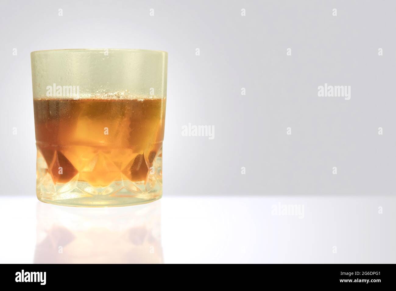 Misted glass with drops of water and whiskey with ice. Sweaty glass of