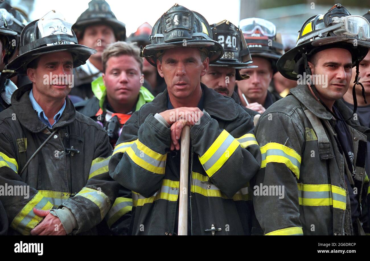 Firefighters look on Friday, Sept. 14, 2001, as President George W ...