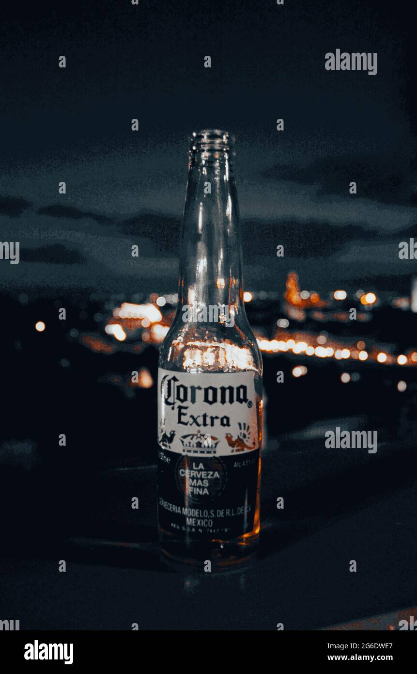 A Corona Extra beer bottle shining in front of the view of Florence Stock Photo