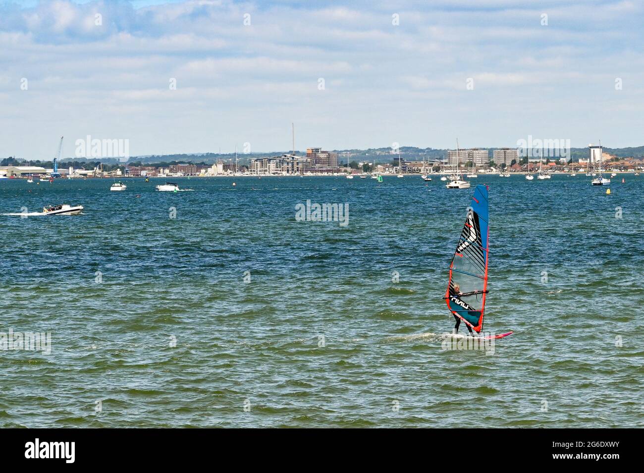 Poole, England - June 2021: Windsurfer on choppy water in Poole harbour. Stock Photo