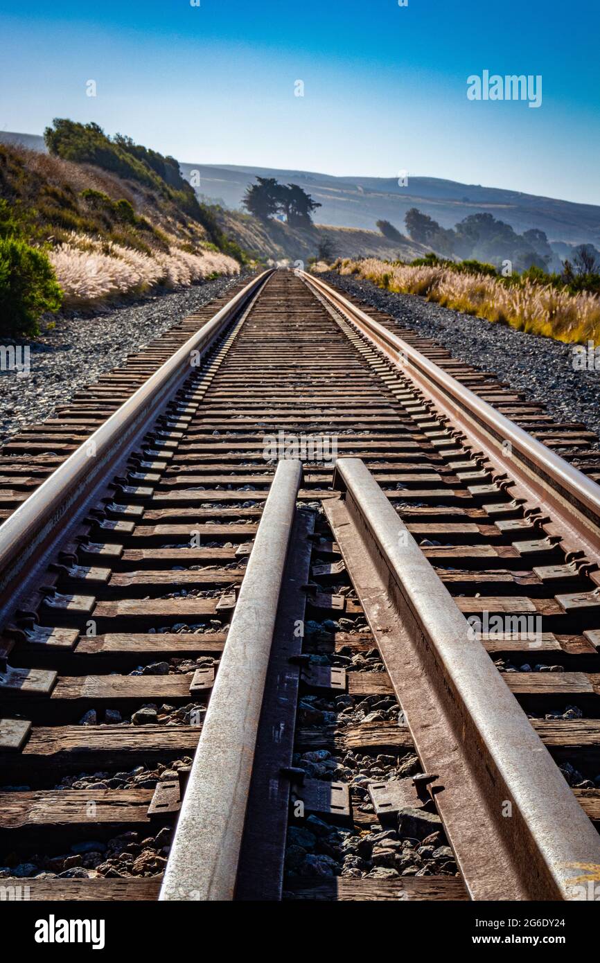 Two converging railroad tracks along the ocean Stock Photo