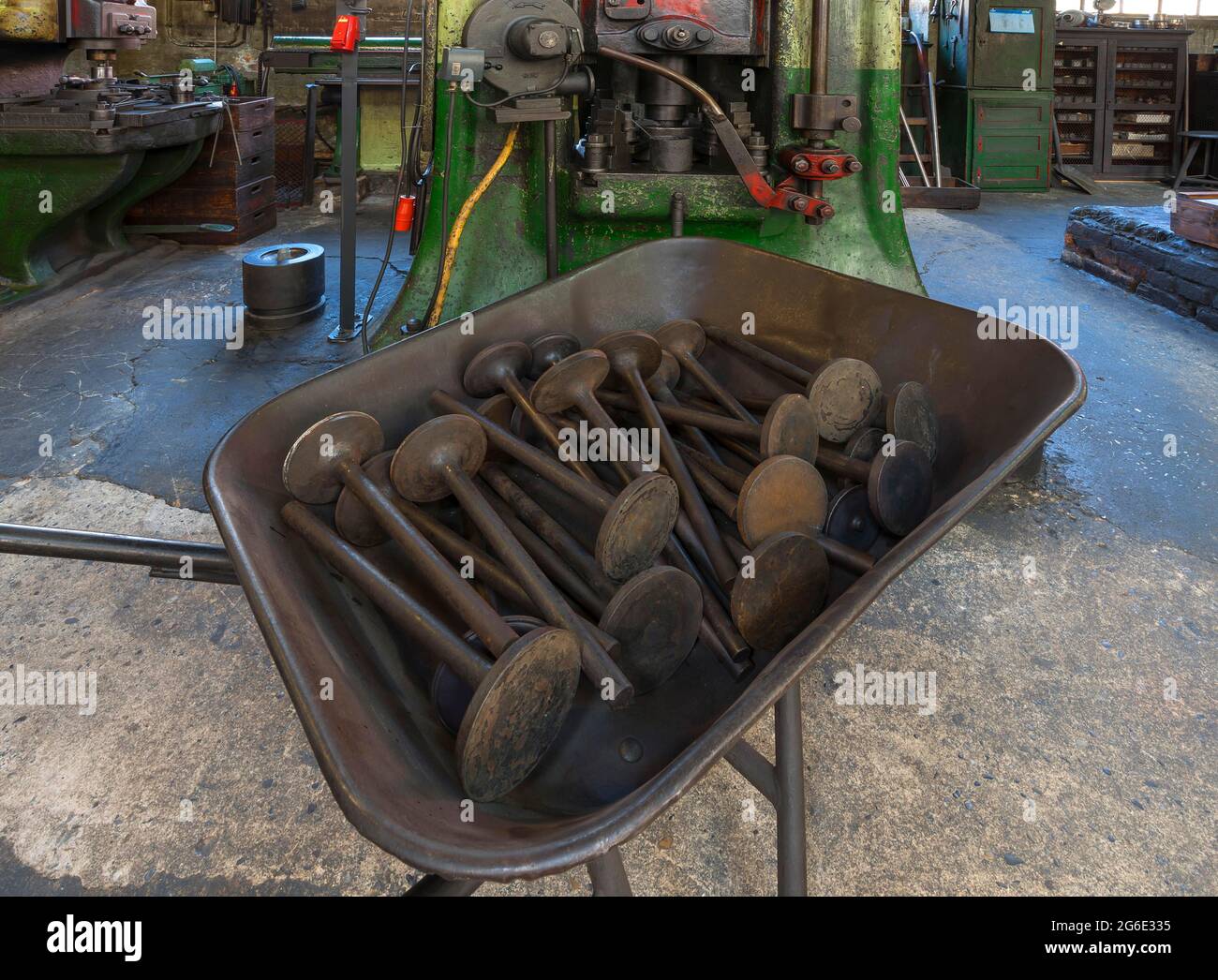 Car valves in the raw state in a wheelbarrow in front of a screw press in a drop forge, Industrial Museum, Lauf an der Pegnitz, Middle Franconia Stock Photo