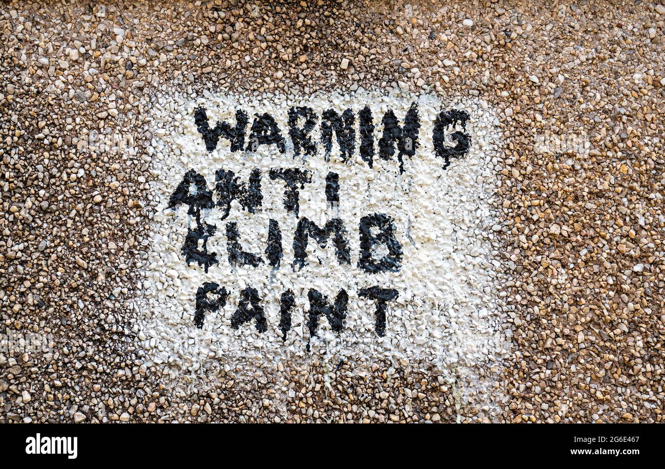 Warning Anti Climb Paint, warning painted on pebbledash wall Stock Photo