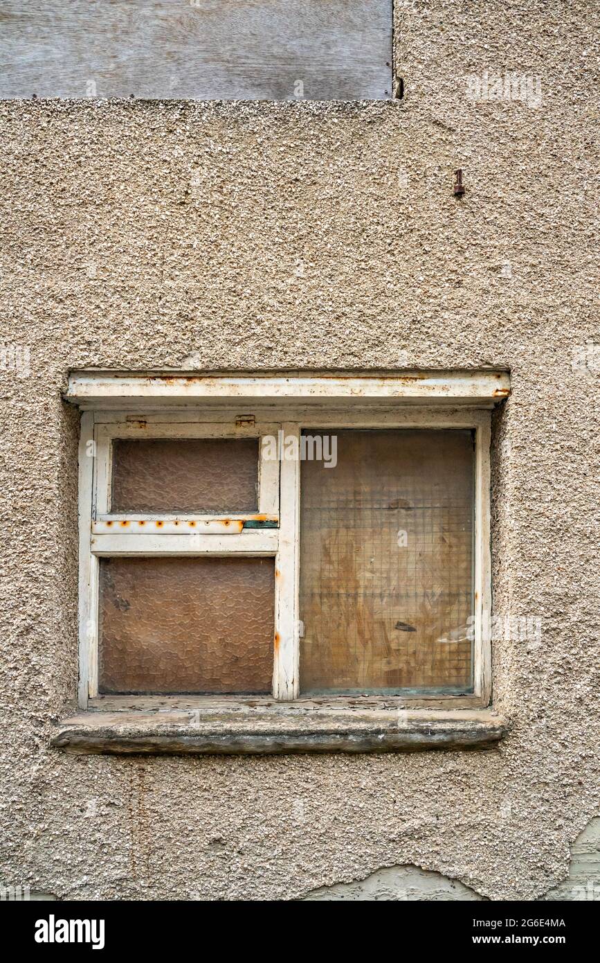 Boarded up window of building in town back street Stock Photo