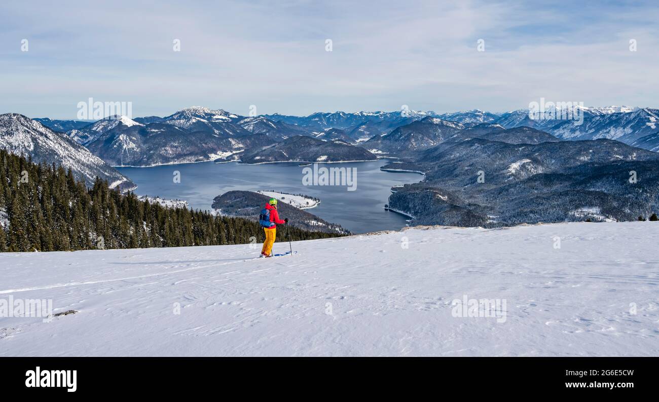 Young woman on ski tour, descent from Simetsberg, view to Walchensee, Estergebirge, Bavarian Prealps, Bavaria, Germany Stock Photo
