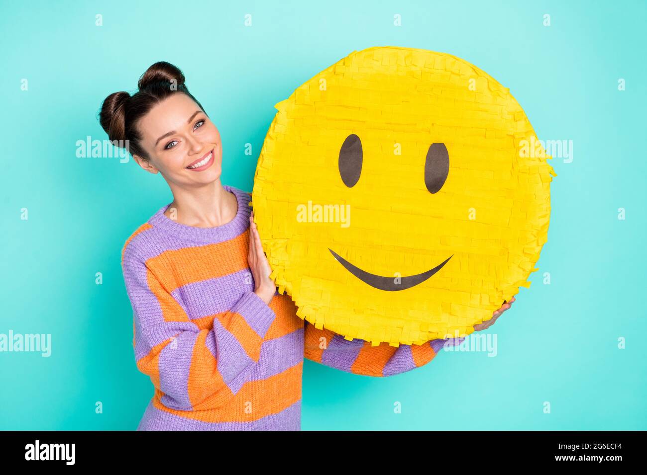Portrait of satisfied young girl arms holding big paper emoji toothy smile  isolated on blue color background Stock Photo - Alamy, image size:1300x956