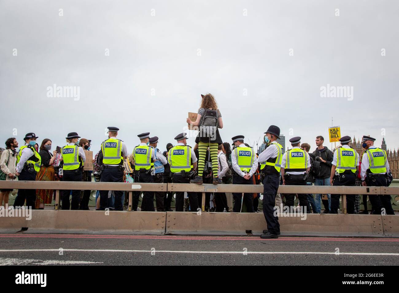 A young protester wearing cats ears and yellow glasses holds up a sign amidst the police at the 'Kill the Bill' Protest in Central London, 5.7.2021 Stock Photo