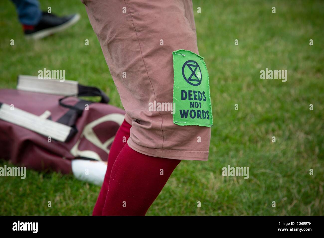 'Deeds not Words' - an Extincion Rebellion badge on a protester's knee at a Kill the Bill protest in Parliament Square, London, 5.7.2021 Stock Photo