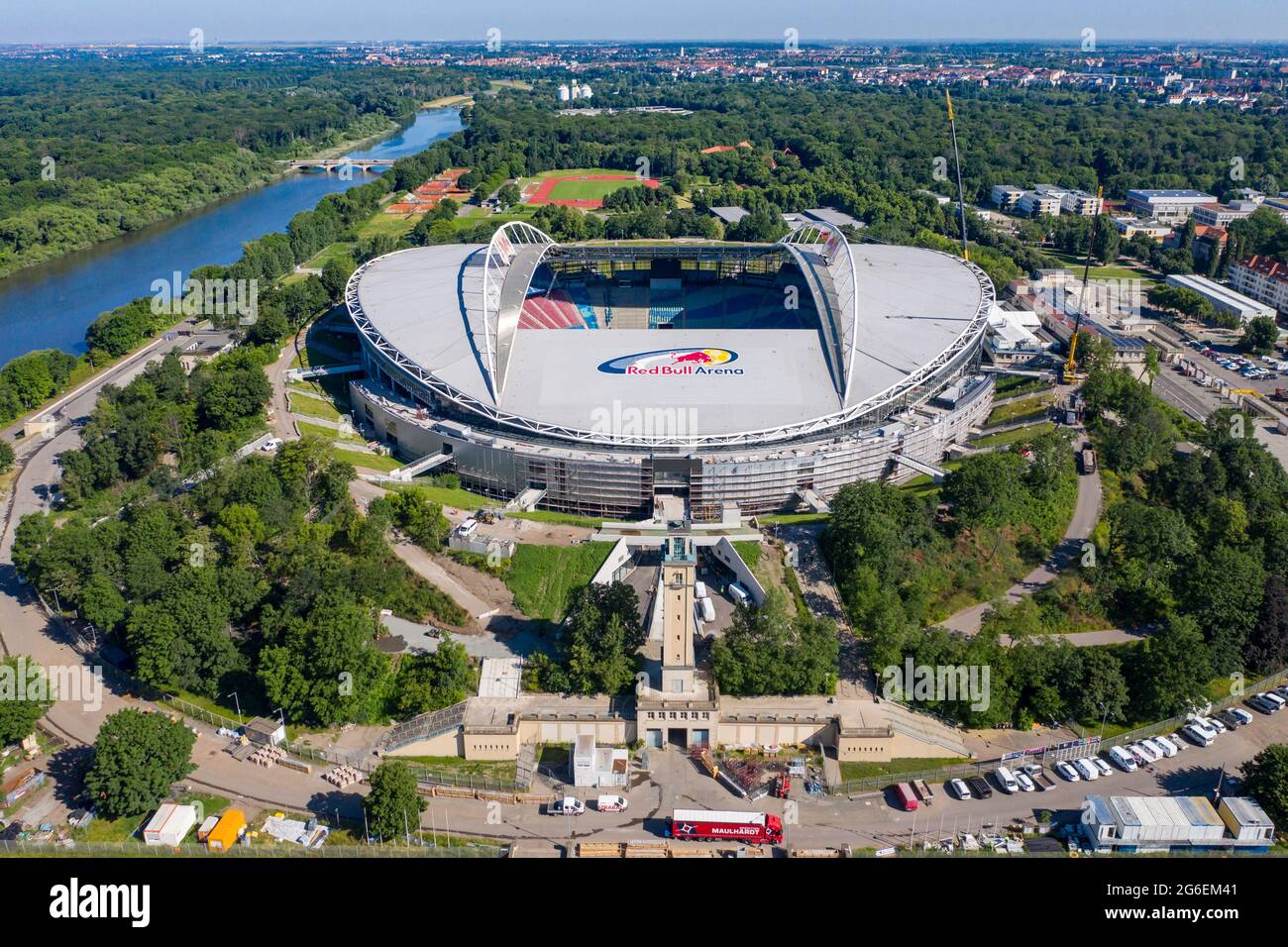 14 June 2021, Saxony, Leipzig: Football: Bundesliga, RB Leipzig. Two cranes and lots of construction vehicles are at the Red Bull Arena. The home ground of the 'Rasenballer' is being rebuilt. The spectator capacity will increase from 42,558 to 47,069 in standing and seated areas. The outside of the stadium is enclosed with a soundproof facade. The embankment of the former Zentralstadion, which encompasses the arena, was cut open behind the historic bell tower to make room for a new entrance. RB Leipzig is investing a good 60 million euros in the conversion by 2022. (Aerial view with drone) Pho Stock Photo