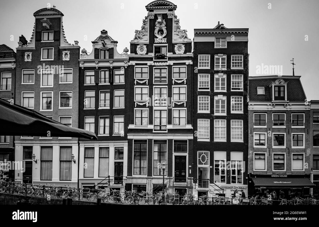 AMSTERDAM, NETHERLANDS. JUNE 06, 2021. Beautiful facades of the old dutch buildings. Restaurants on the street Stock Photo