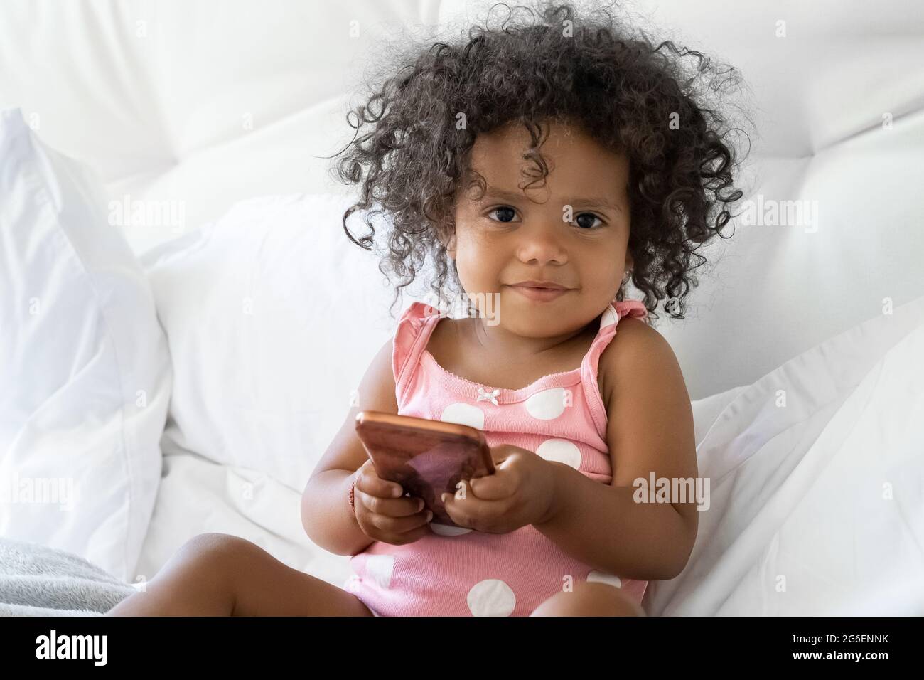 Portrait of little afro american girl child with mobile phone looking at camera Stock Photo