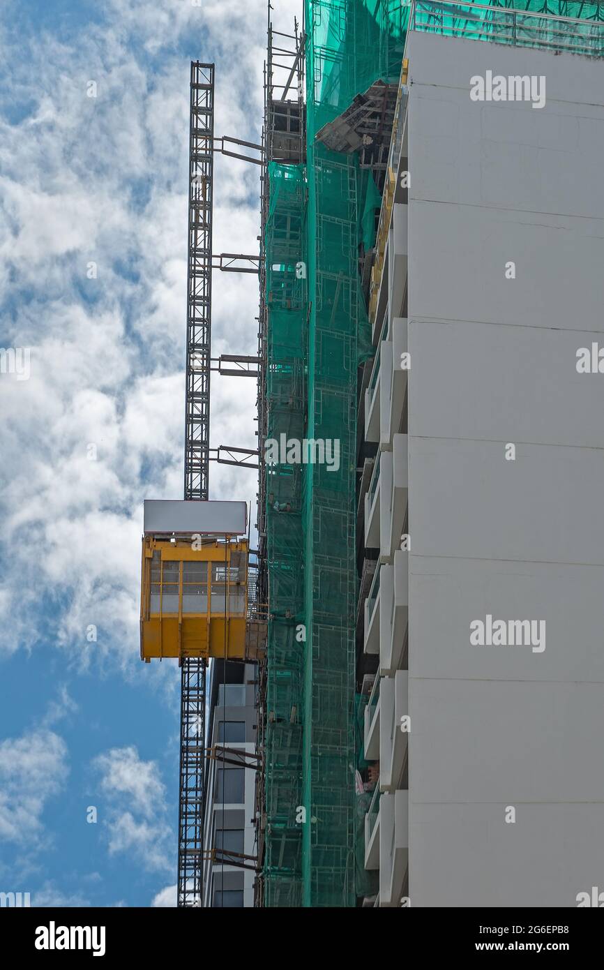 Hoist lift platform for transporting passengers and materials at a construction site.  Construction elevator cage. Stock Photo