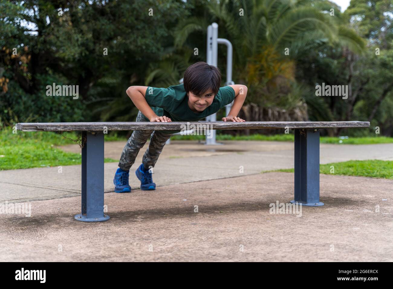 oung boy doing push ups. Healthy child doing exercise. Stock Photo
