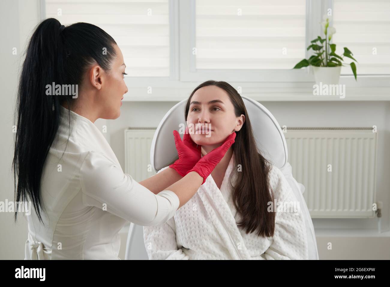 Cosmetologist checking face skin condition during skin examination in 
