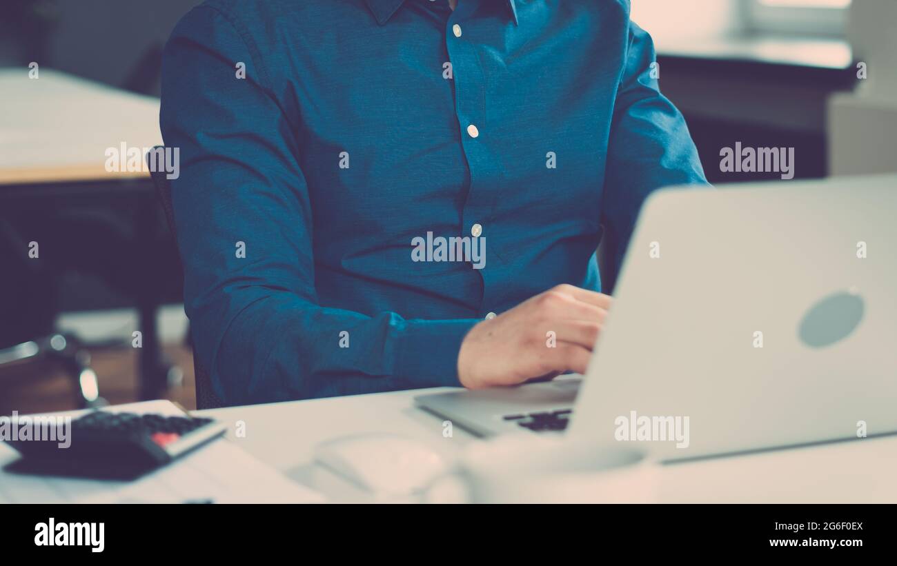 Cropped faceless man freelancer working on laptop computer remotely Stock Photo