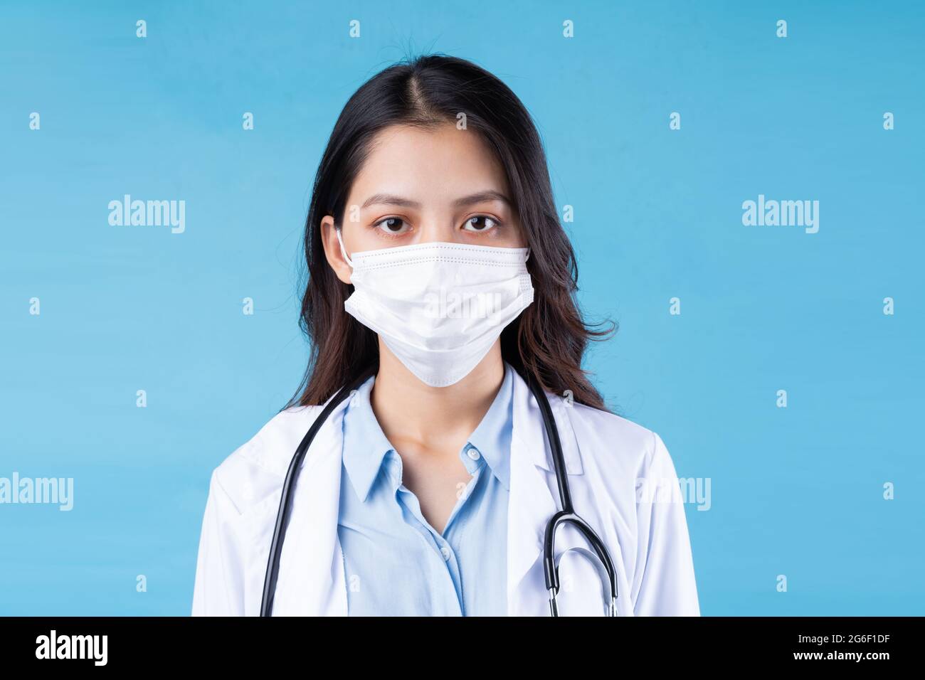 portrait of young female doctor, isolated on blue background Stock Photo