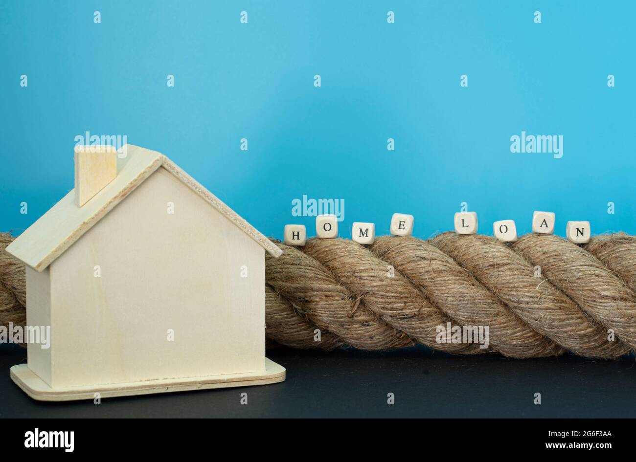 Financial concept. Rope, house model and wooden blocks with text. Selective focus points. Stock Photo