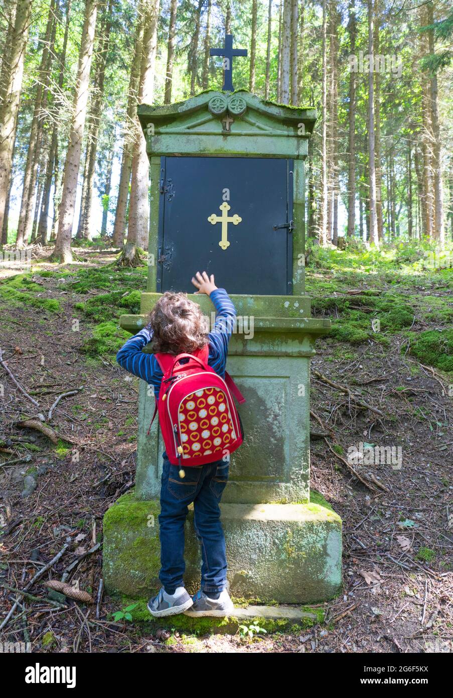 Cute toddler pray in forest for peace in the world Stock Photo