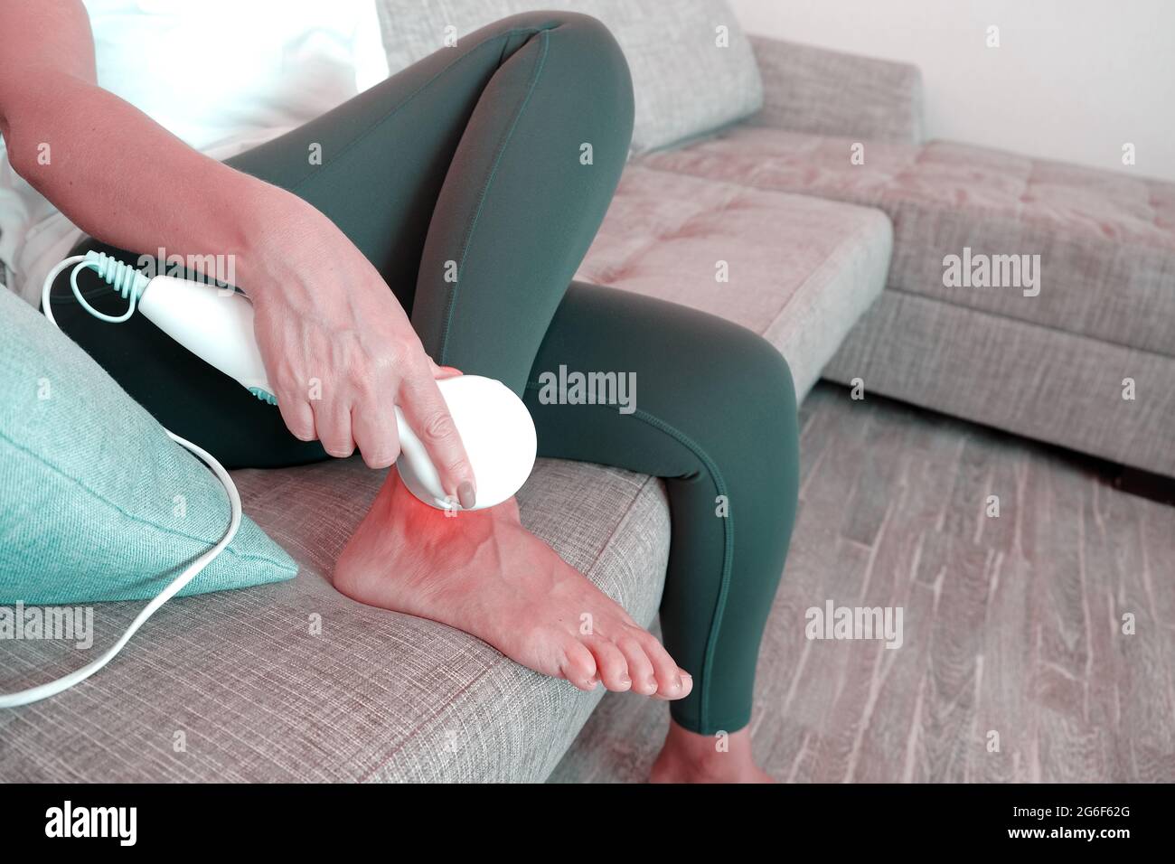 Treatment of joint inflammation.Infrared massage device for the body, for muscle pain, sprains, circulatory disorders and fatigue phenomena Stock Photo