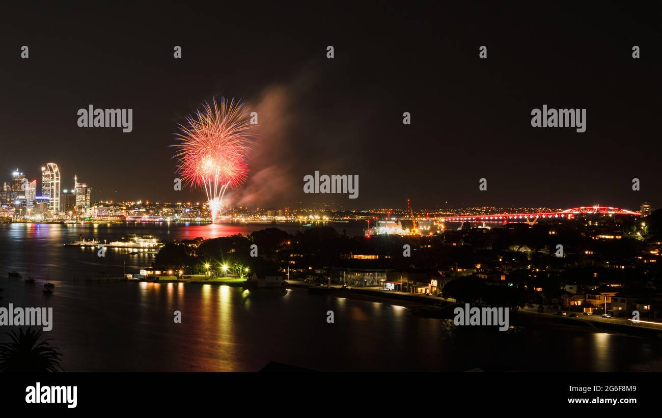 Fireworks display with Harbour bright illuminated in red, Auckland city. Stock Photo