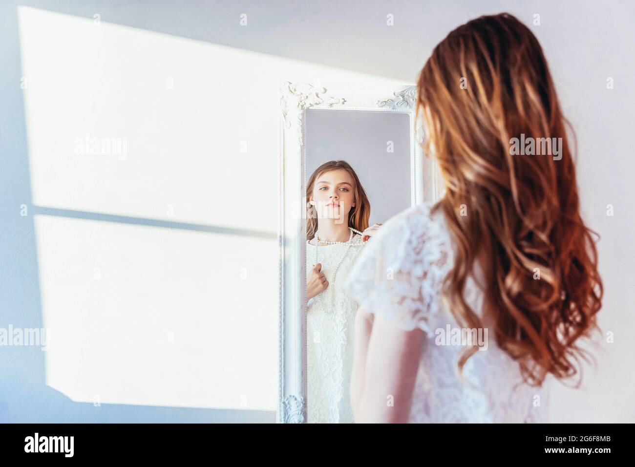 Beauty makeup morning rutine love yourself concept. Young teenage girl  looking at reflection in mirror. Young positive woman wearing white dress  Stock Photo - Alamy