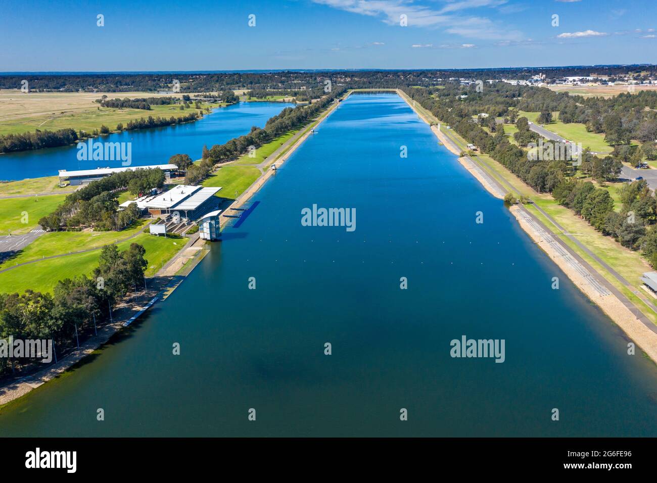 Aerial view of blue water at a rowing centre surrounded by green agricultural fields in regional Australia. Stock Photo