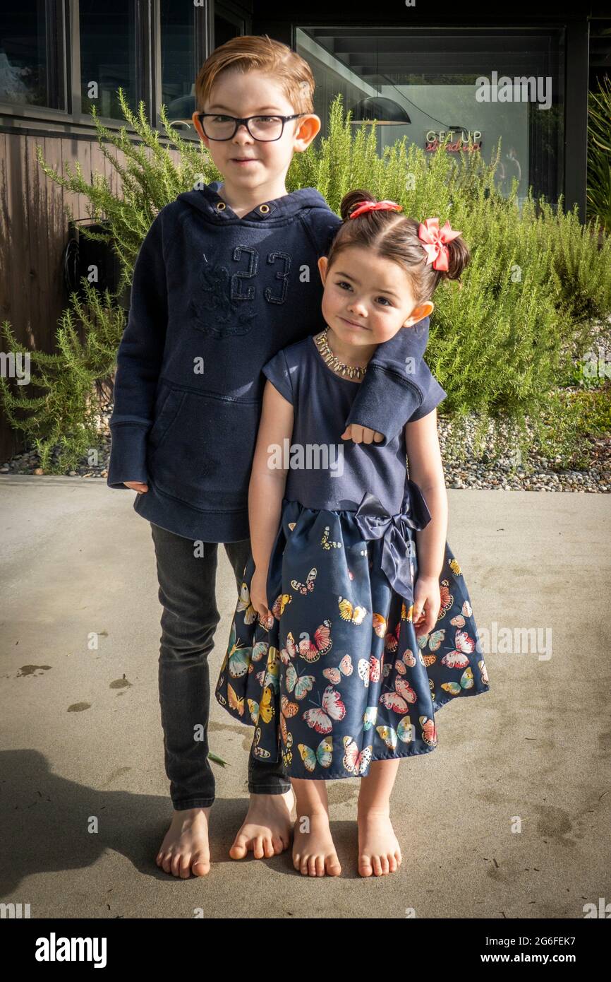 A brother, 7 and his sister, 4, pose on the patio of their home in West Vancouver, BC, Canada. Stock Photo