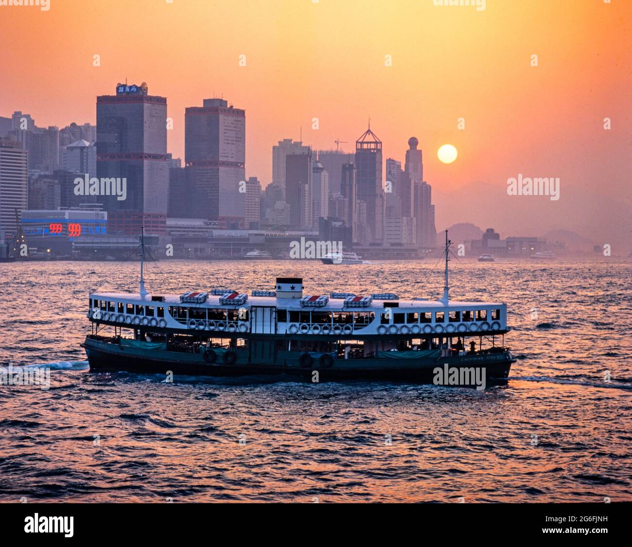 Star Ferry crossing Victoria Harbour at sunset, Hong Kong, SAR, China Stock Photo