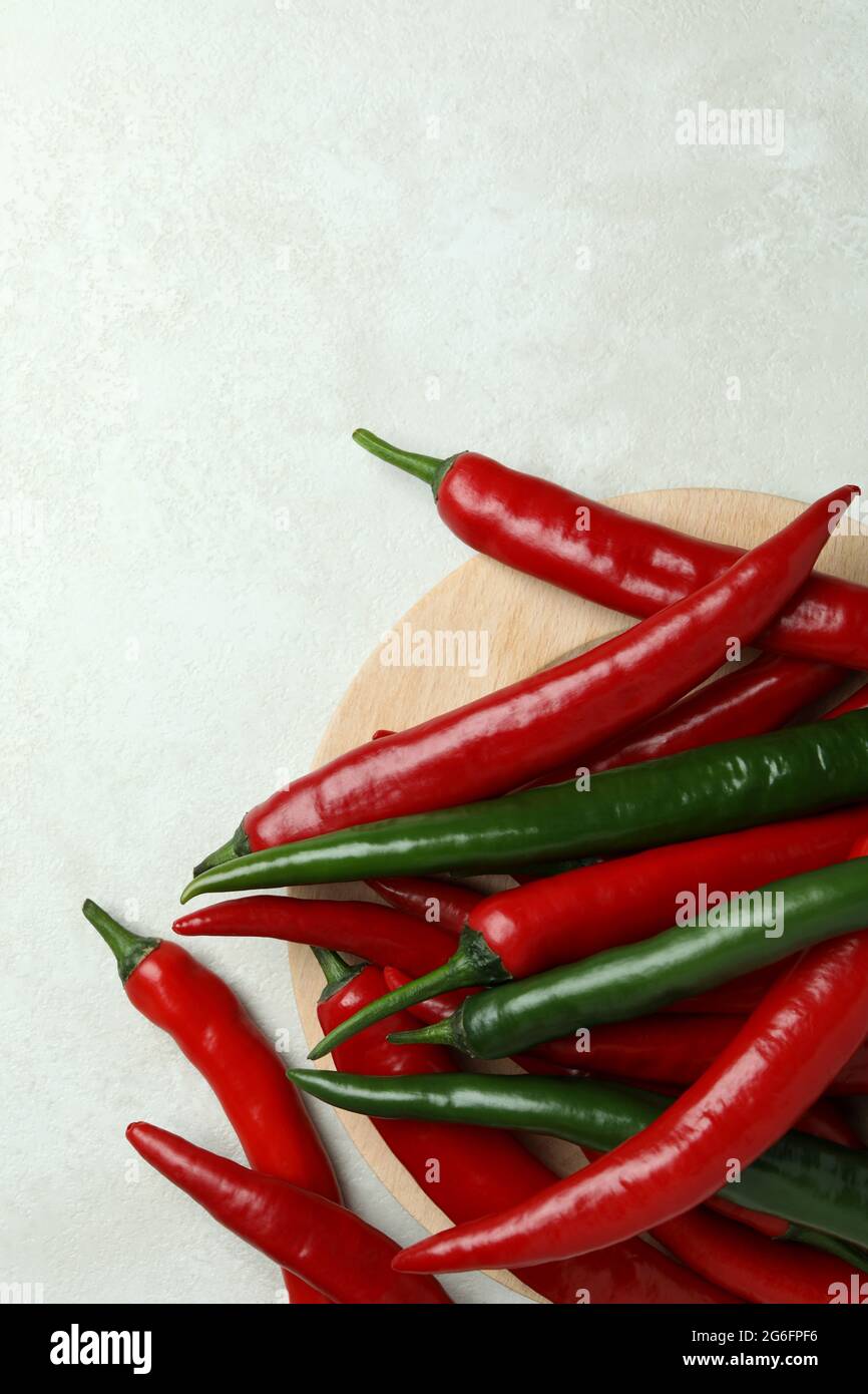 Red and green peppers on white textured background Stock Photo - Alamy