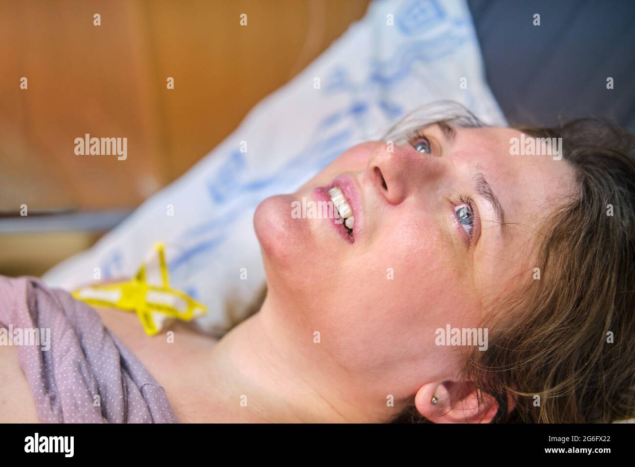 Portrait of a happy mother immediately after a successful birth on the bed in the maternity ward Stock Photo