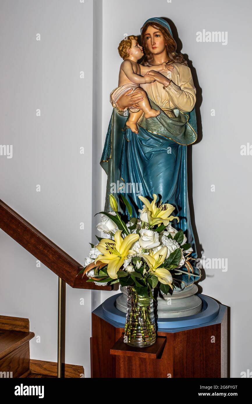 Beautiful bouquet of flowers before the statue of Mary holding the Baby