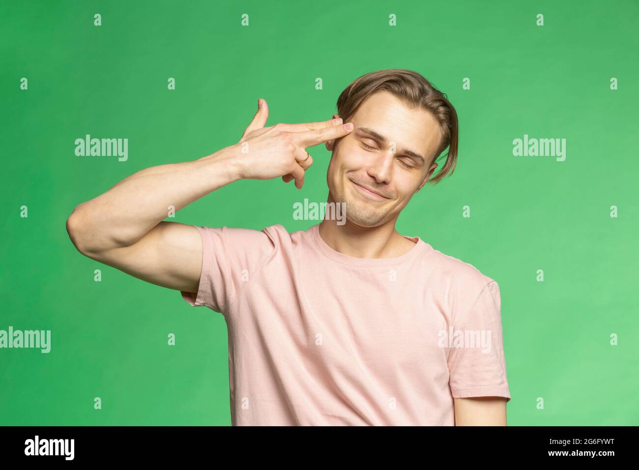 Portrait young man holding finger gun to head Stock Photo