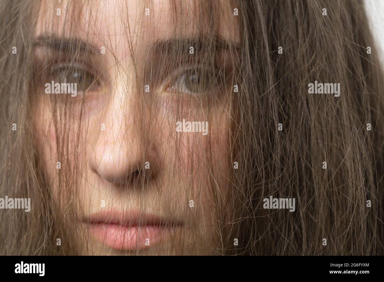 Close up portrait hair in face of beautiful young brunette woman Stock Photo