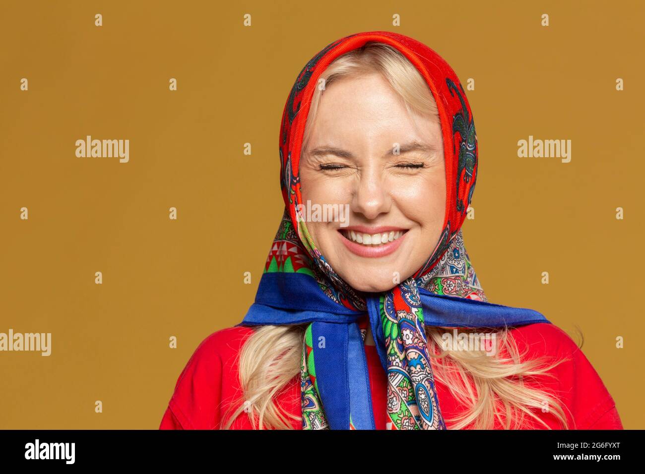 Portrait carefree woman in colorful babushka headscarf Stock Photo