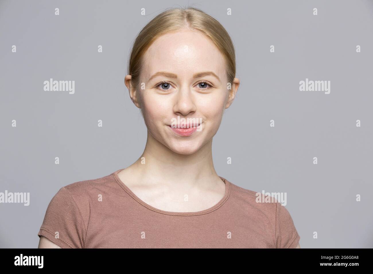 Portrait confident smiling young woman on gray background Stock Photo