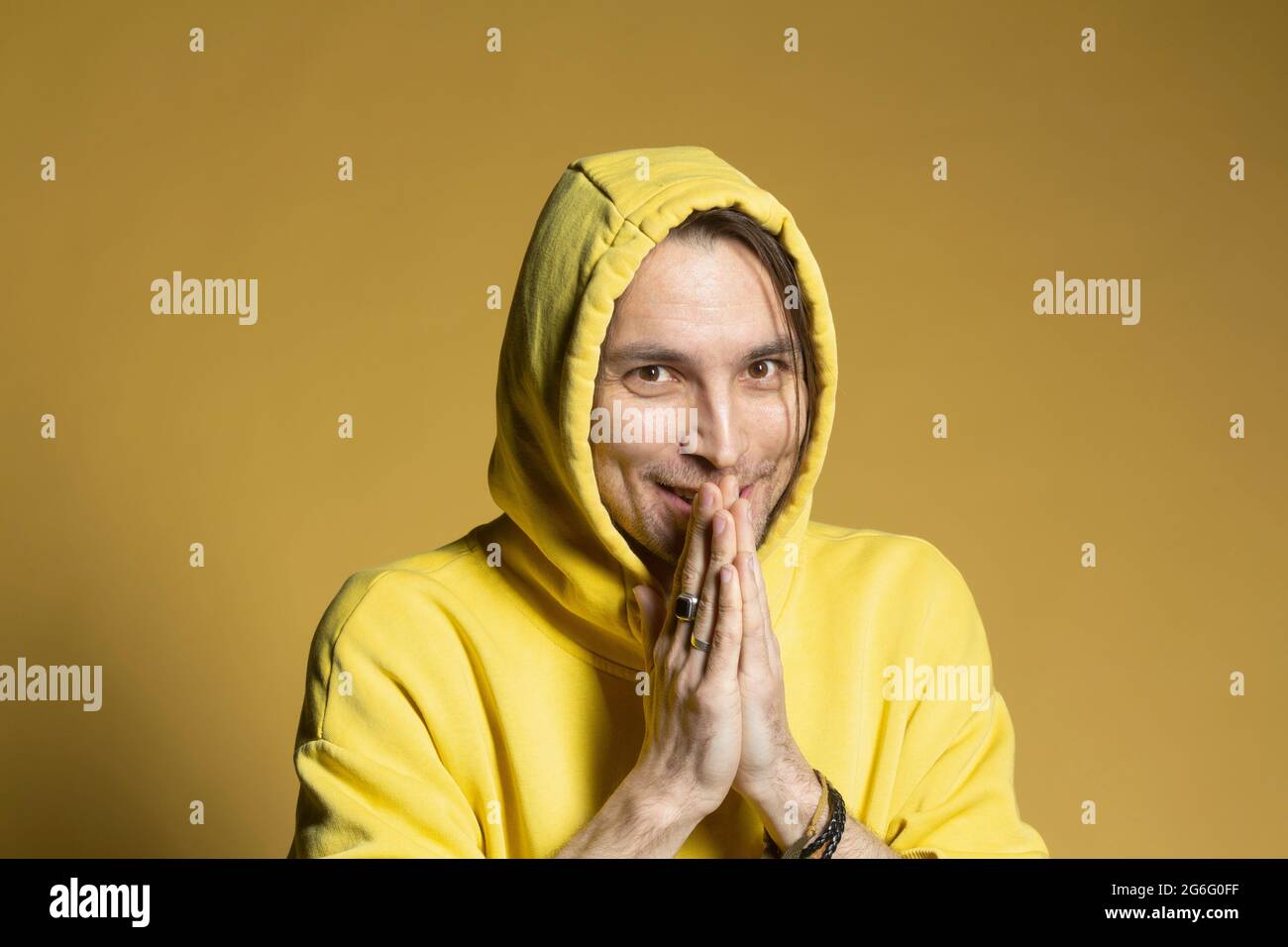 Portrait excited man in yellow hooded sweatshirt Stock Photo