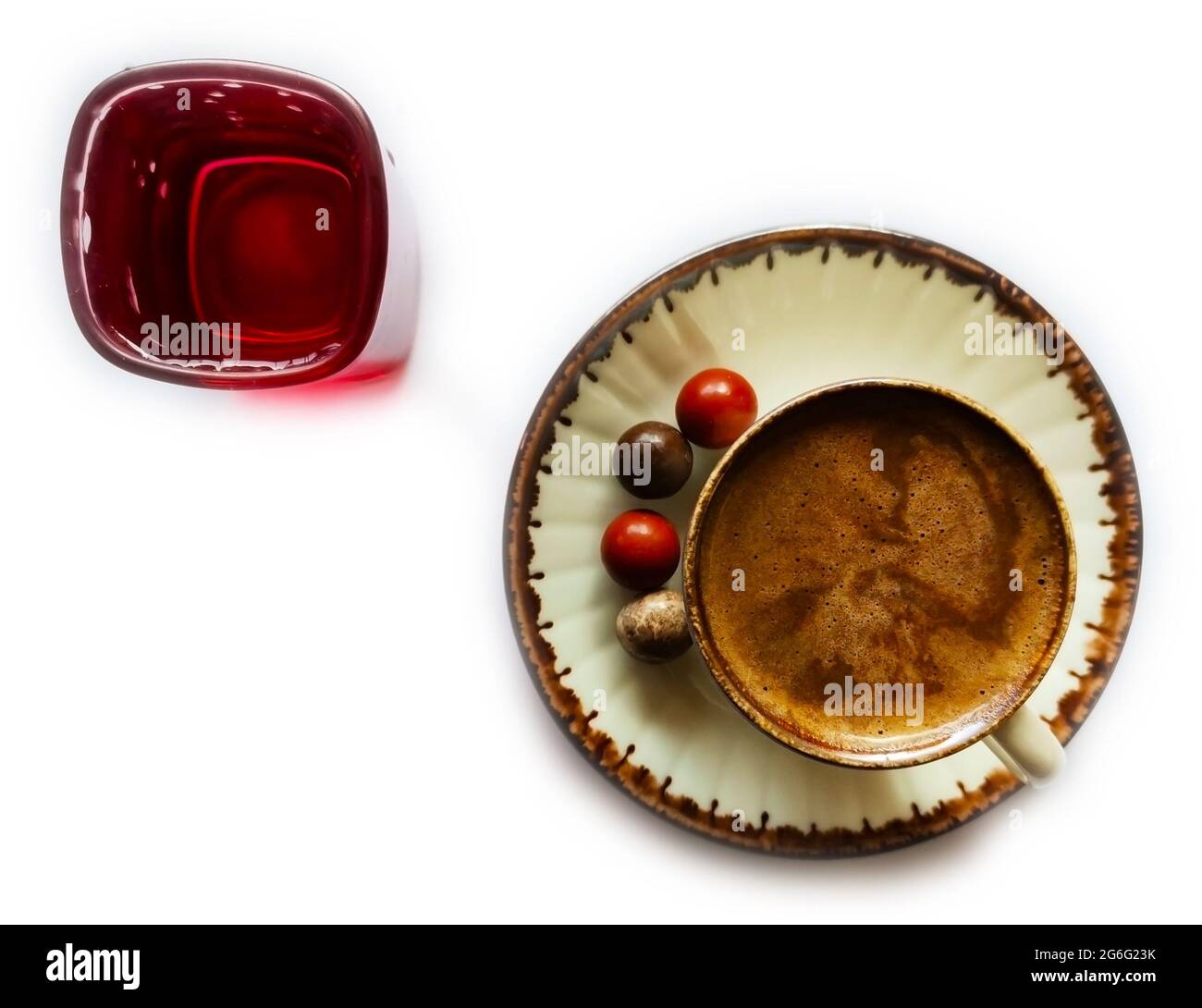 Turkish coffee on white background and front. Colored chocolate next to the coffee and water in a red glass. Stock Photo